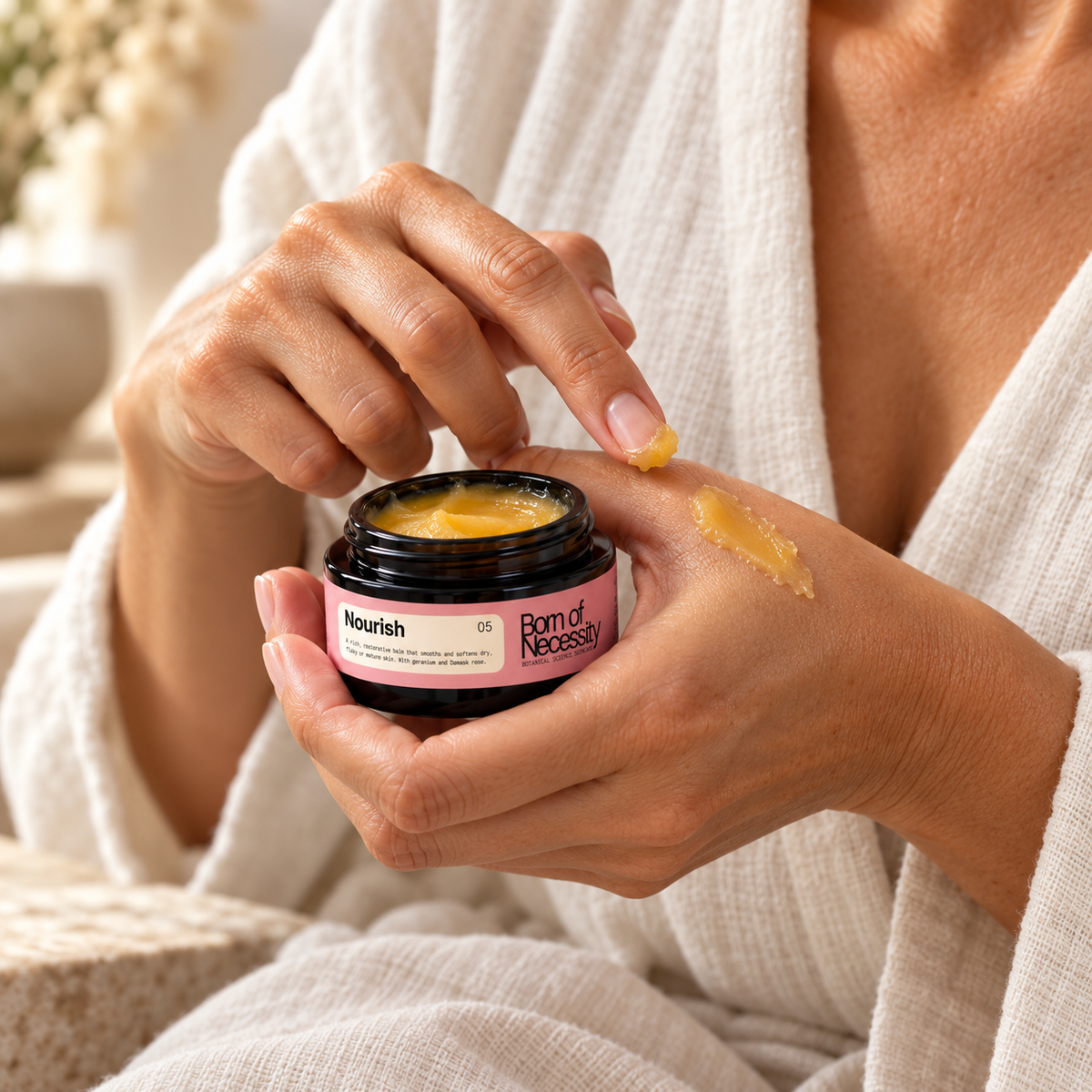 Nourish golden balm being applied to the back of a hand