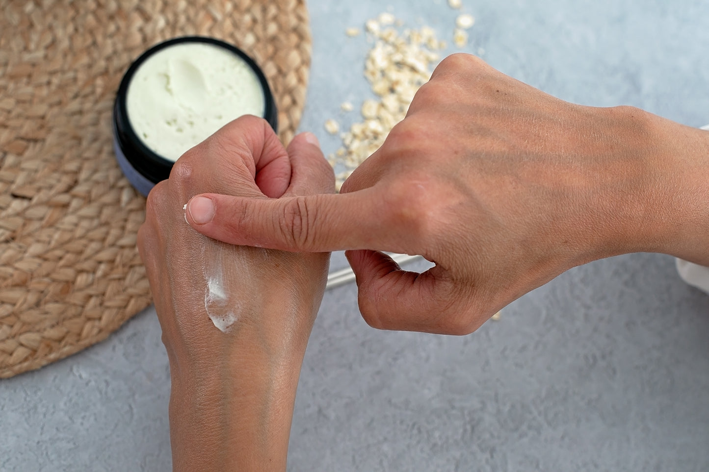 Applying Heal & Restore Body Balm for eczema, with Hemp & Oats on hand, showcasing natural, organic skincare for sensitive skin.
