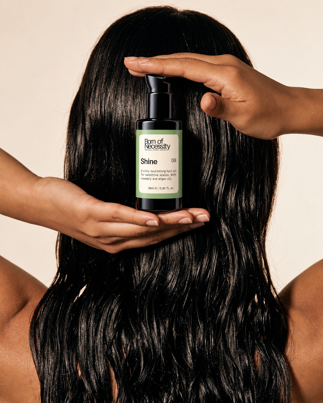 Shine hair oil held against long dark hair.